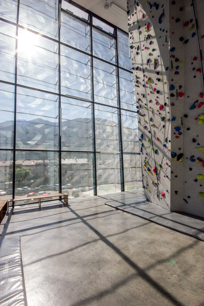Hohe Kletterwand hinter der Glasfront