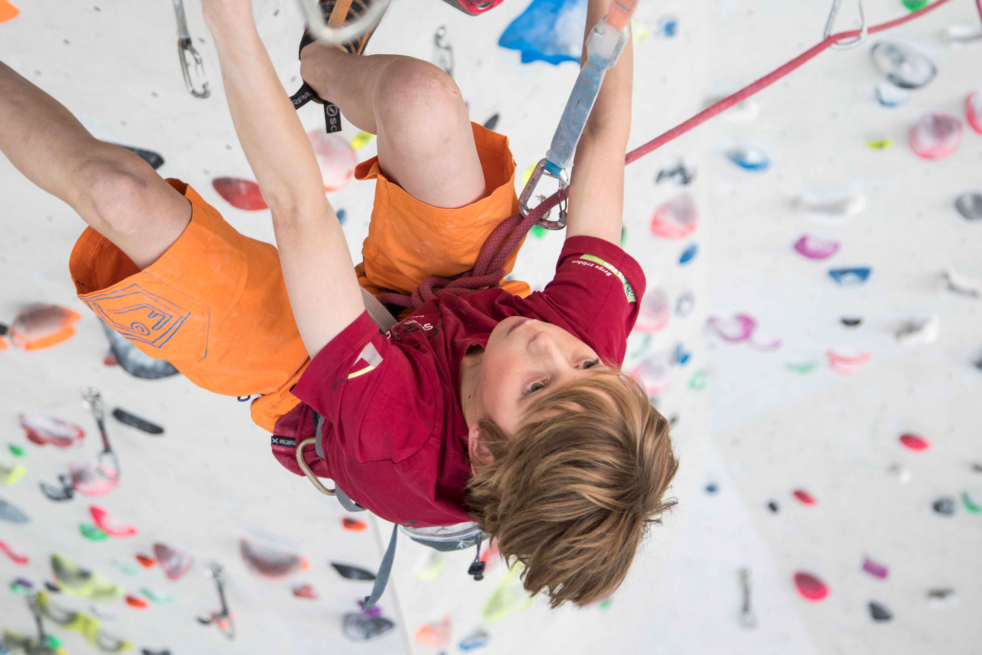 Junge im Kletterkurs an der Wand